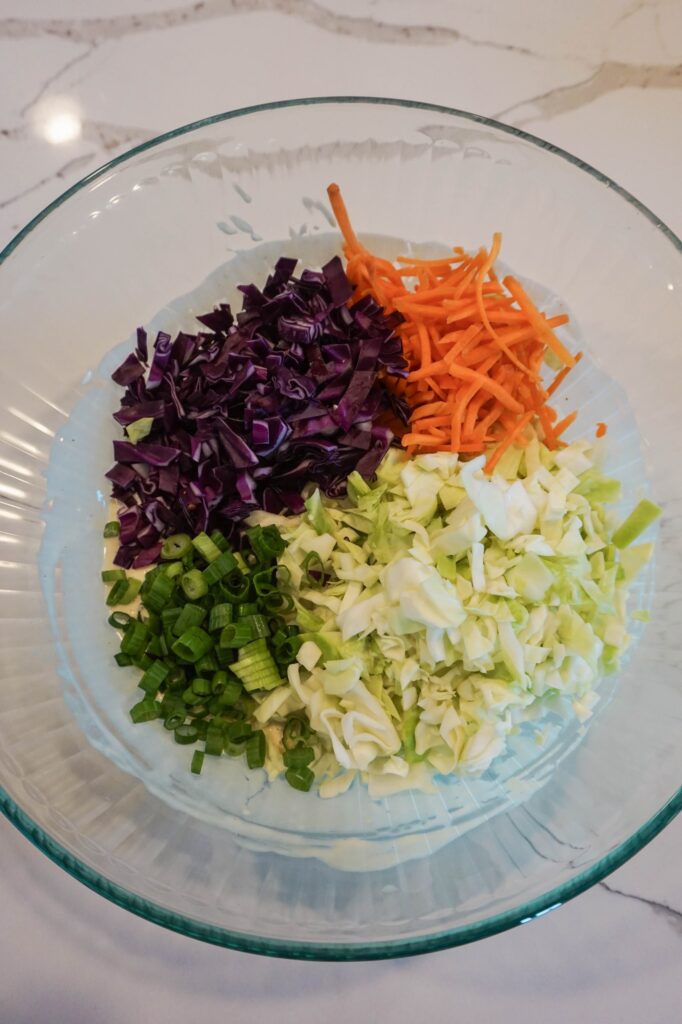 coleslaw recipe ingredients in a large mixing bowl